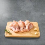 Baby drumsticks on a wooden cutting board