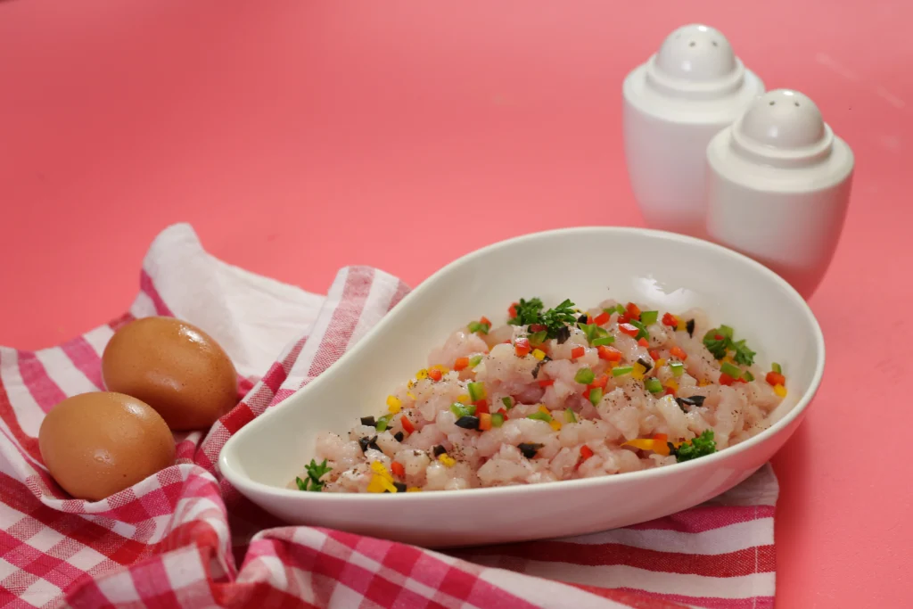 Anthoney’s minced chicken breast meat on a plate with two eggs on side